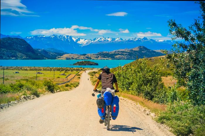 A cyclist navigating the dirt roads of the Carretera Austral highway