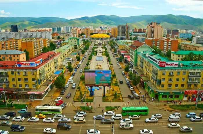 Busy streets and intersections filled with vehicles in a city nestled among hills