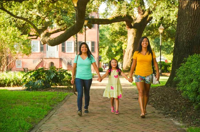 Two women stroll through Savannah, each holding hands with their daughter.