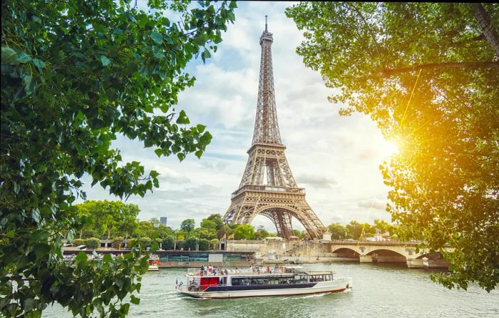 A riverboat glides past the Eiffel Tower.