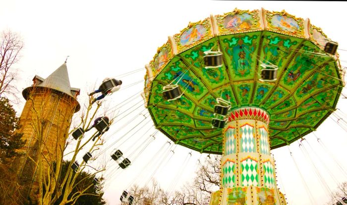 A spinning carousel with swings flying out as it twirls