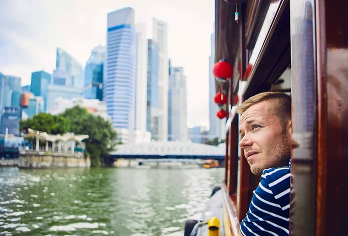 A man gazing out the window of a ferry in Singapore.