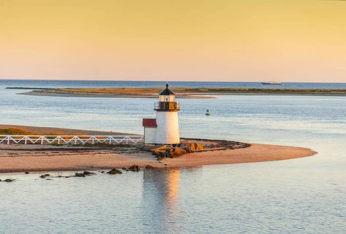 A sturdy lighthouse standing at the island's edge, surrounded by calm waters.