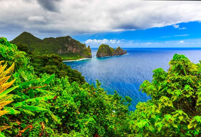 A lush, rocky island surrounded by deep blue waters under a partly cloudy sky.