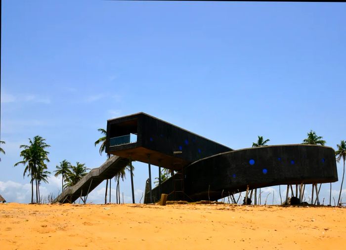 A striking black elevated walkway on the beach at Badagry, Nigeria, marks the Point of No Return, a historic slave port on the Atlantic Ocean.