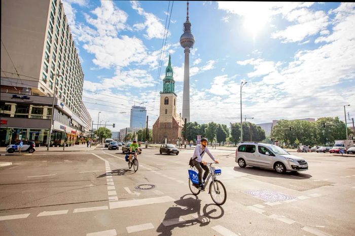 In the morning, cyclists and traffic flow past Saint Mary's Church and the Fernsehturm.