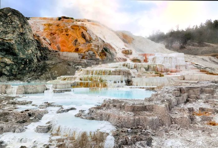 A hillside adorned with layered rock formations coated in white mineral deposits.