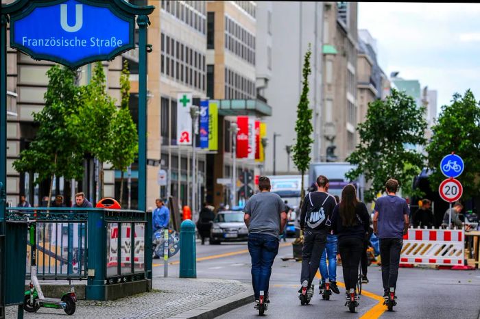 E-scooter riders cruise along Friedrichstrasse in Berlin.