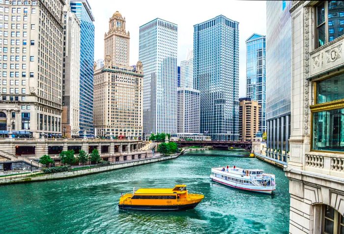 Passenger boats glide through the canal, surrounded by a bustling city skyline filled with skyscrapers.