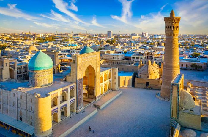 A stunning complex of mosque buildings featuring two blue tiled domes and a tall minaret