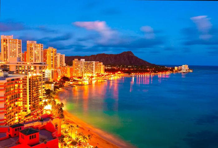 The coastline comes alive with soaring buildings that shine brightly, while the iconic Diamond Head stands majestically in the background.