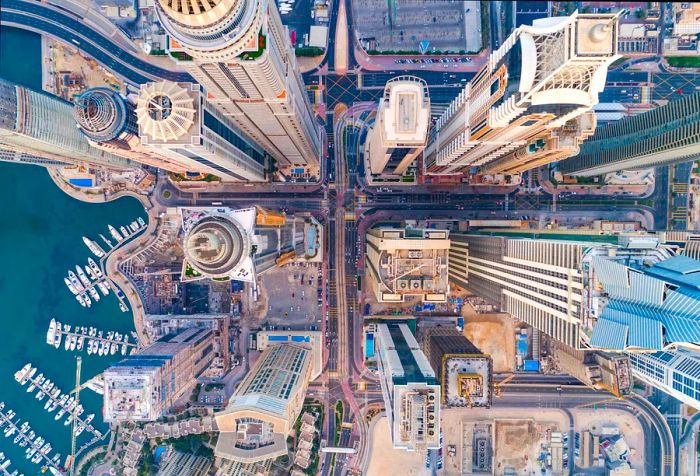 An aerial view of Dubai showcases its impressive skyline, with towering skyscrapers and a bustling marina.