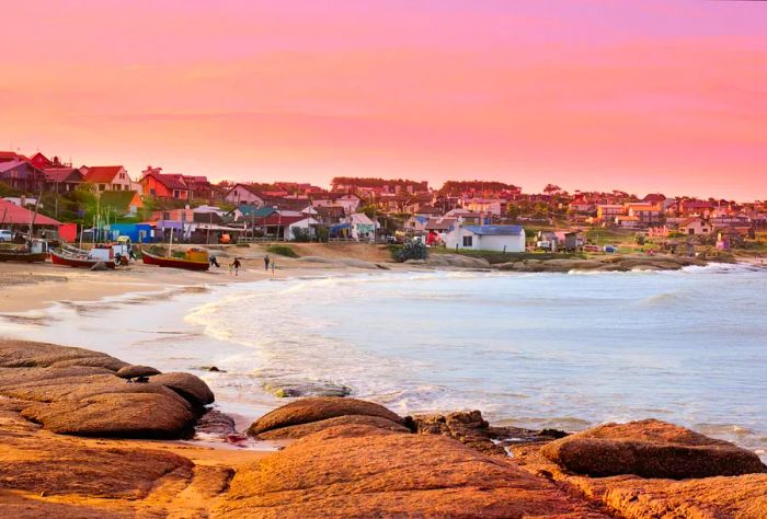 A charming fishing village with colorful old houses overlooking the calm sea under a beautiful twilight sky.