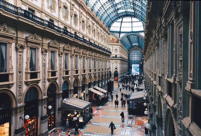 In Milan, a historic shopping arcade features a breathtaking skylight that bathes the elegant stores and bustling visitors in natural light, showcasing this architectural gem.