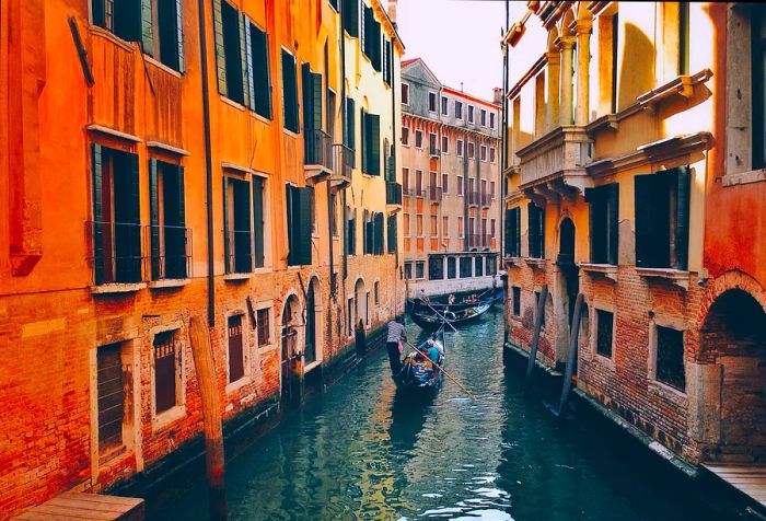 Boats glide smoothly through a tranquil canal, flanked by buildings on both sides.