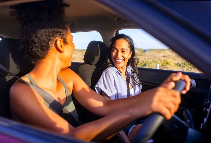 Two friends enjoying their time during a car journey.