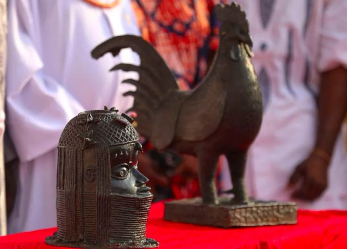 The two artifacts, which consist of a bronze cockerel and a bust looted from Nigeria by British military forces over 125 years ago, are now displayed on a table within the Oba of Benin's palace in Benin City, where they were originally taken.