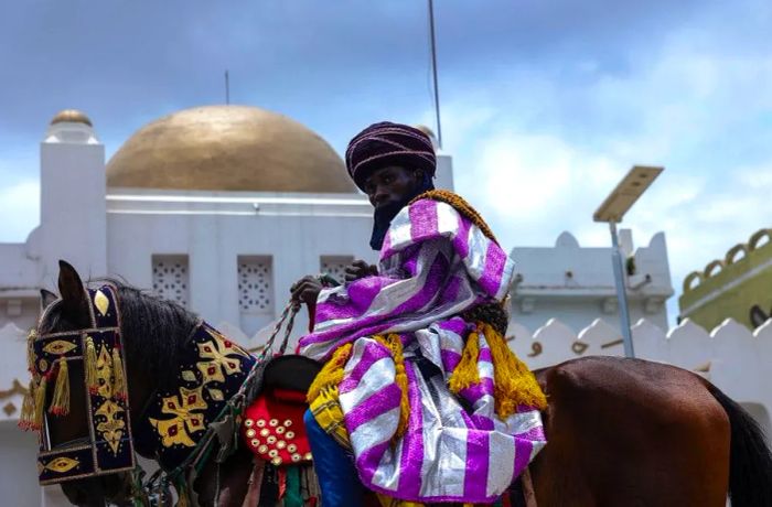 A rider passes by the Emir's Palace during the Durbar Festival in Ilorin