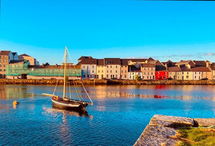 A solitary boat anchored in the bay, flanked by traditional buildings with charming brown roofs.