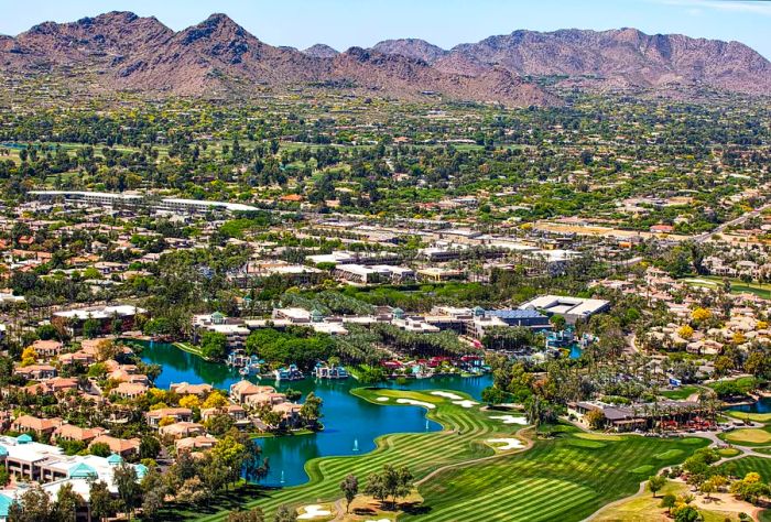 Aerial view of Scottsdale, Arizona, showcasing golf courses, resorts, luxury homes, and Mummy Mountain to the southwest.