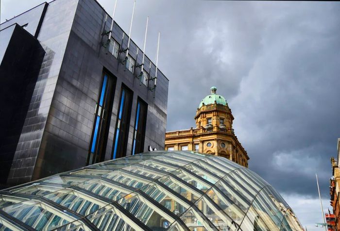 A view of various building rooftops seen from beneath a glass dome on a cloudy day.