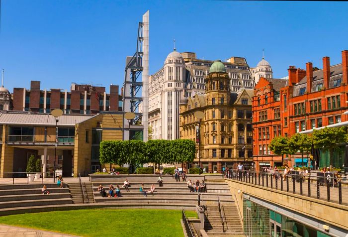 A view of Great Northern Square showcasing a unique design of tiered benches, surrounded by towering buildings.