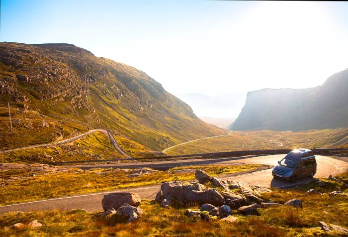 A campervan navigates the Applecross pass in North West Scotland, UK.