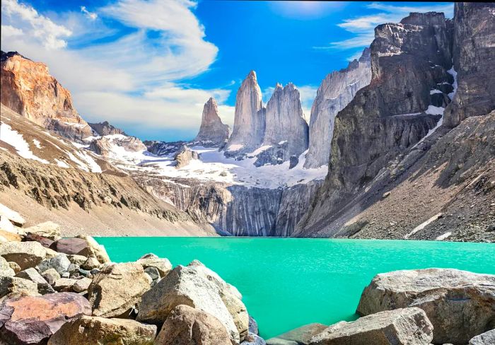 A stunningly blue lake nestled among the gray peaks of the Torres del Paine mountains in Patagonia, Chile.