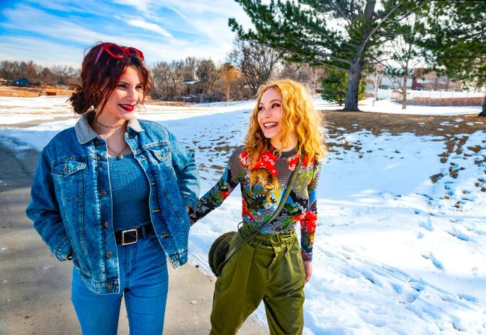 A photo of two Hispanic teenage sisters enjoying a sunny winter day outdoors in Denver, Colorado