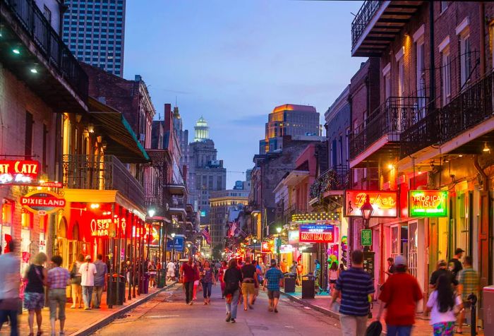 A vibrant night view of a bustling street filled with restaurants and bars, aglow with bright neon signs.