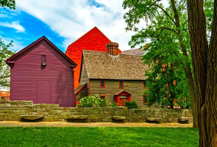 A row of charming gable-roofed wooden homes behind a low brick wall.