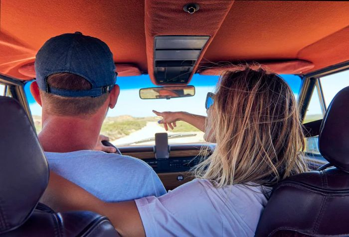 A couple enjoys a moment of intimacy in their car, cherishing their travels together.