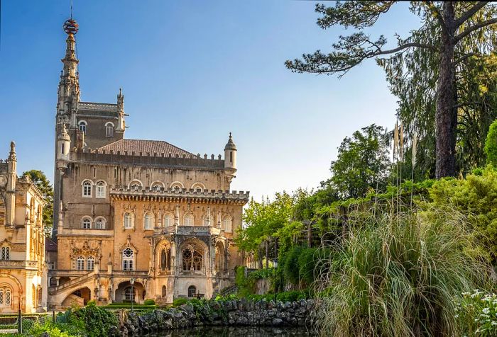 A view of an ornate ancient palace set within a sprawling garden on a sunny day.