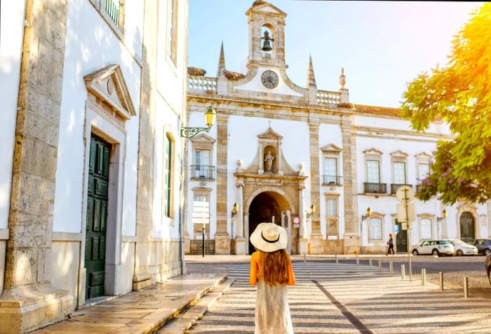 A young traveler poses confidently in front of an ancient church set within the city.