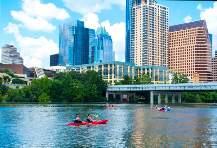 Canoers enjoying the waters of Lady Bird Lake with the Austin skyline providing a stunning backdrop.