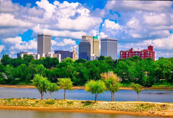 A river flows through a forested area, offering distant views of the city skyline.