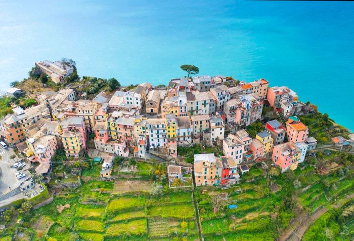 An awe-inspiring view of a charming village with colorful houses perched on a cliff, overlooking the ocean.