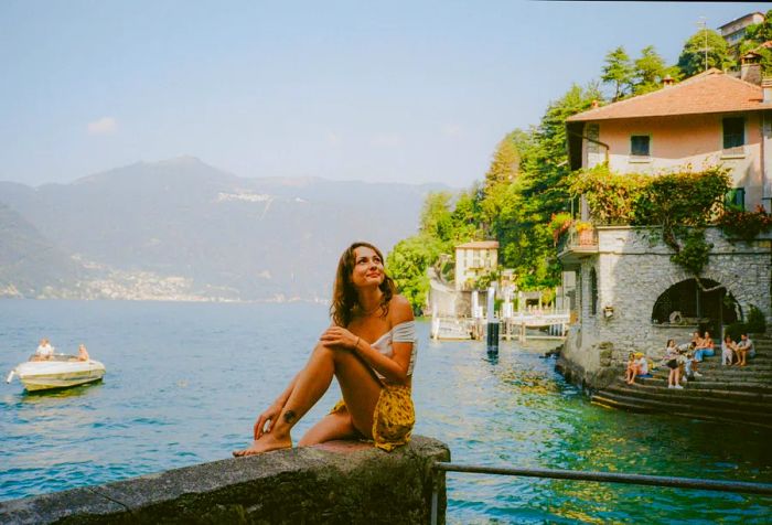 A woman relishes her vacation by the shores of Lake Como in Italy.