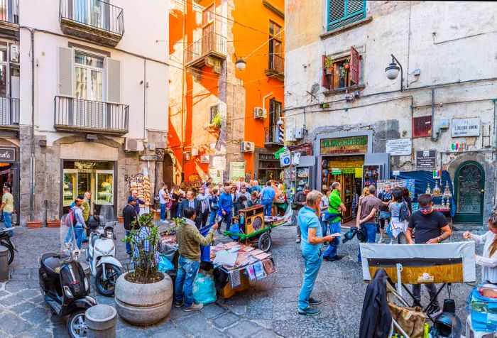 A lively city square flanked by traditional commercial buildings.