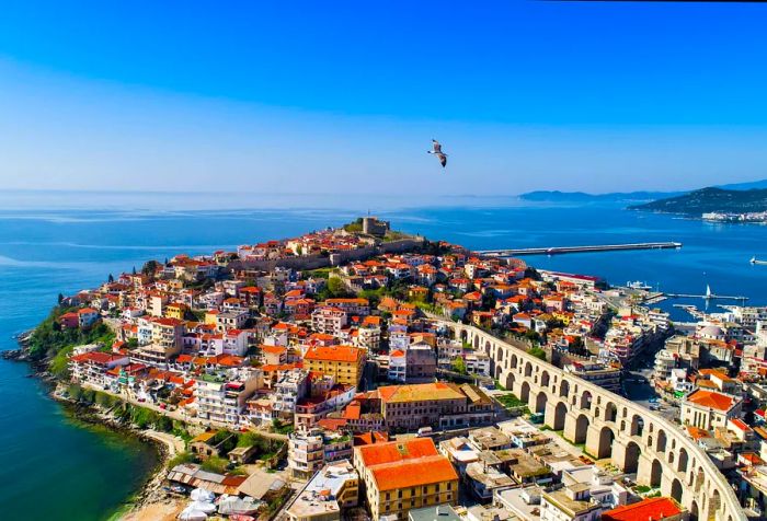 A bird soars above an aqueduct that spans the urban landscape of this coastal city.