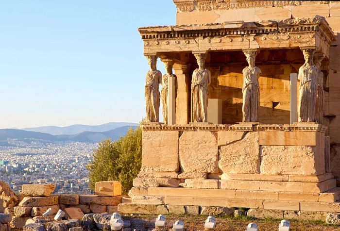 Six statues of young women grace the porch of an ancient temple within the ruins of the Acropolis.