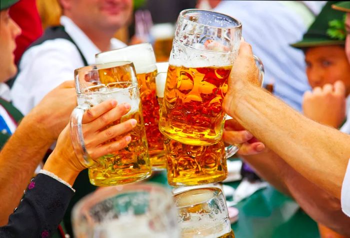 A group of people joyfully clinking their beer mugs together.