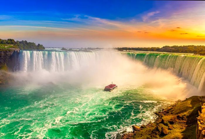 A vessel nearing the foot of a towering, roaring waterfall.