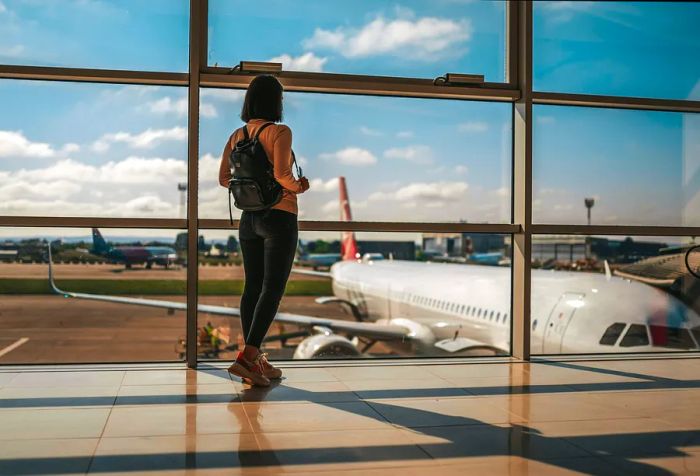 Image of a joyful traveler at the airport, highlighting the departure terminal and immigration process.