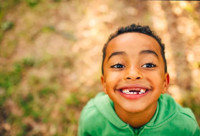 A portrait of a joyful little boy with gaps between his teeth.