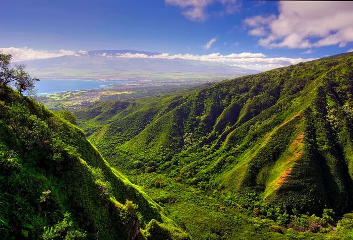 Lush, green mountain range contrasting against a clear blue sky.