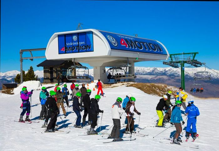 Skiers enjoy the snowy mountaintops, with a chairlift station visible in the background.