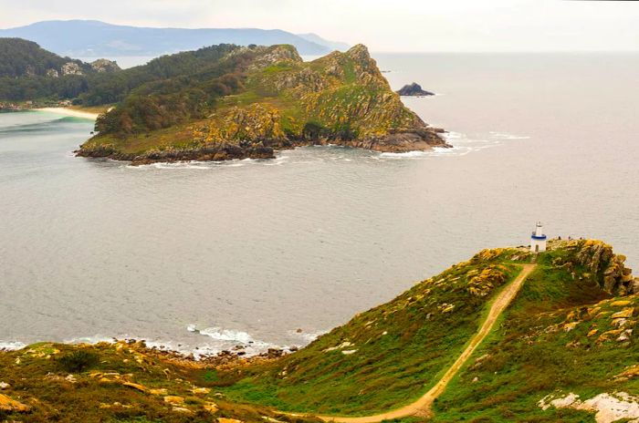 A rugged coastline with a cliff crowned by a lighthouse.