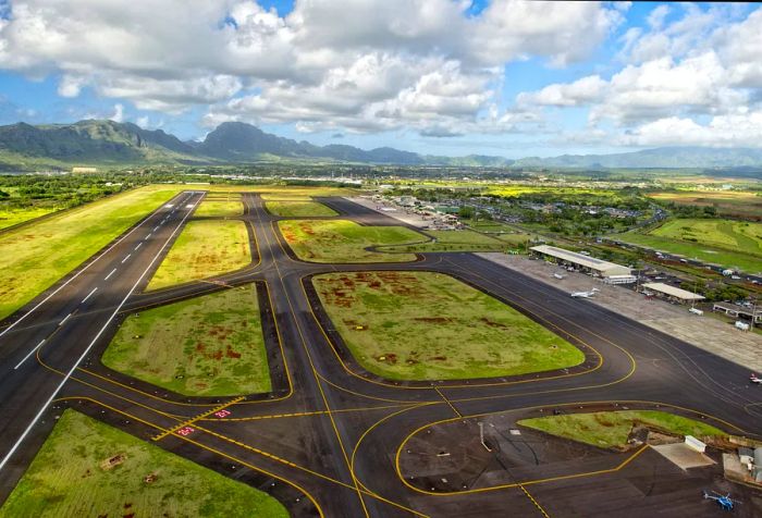 A runway area interspersed with patches of greenery between the taxiways and terminals.