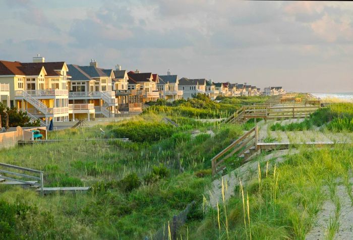 Lined with tall wooden houses, the coastline features boardwalks winding through bushy dunes leading to the sea.